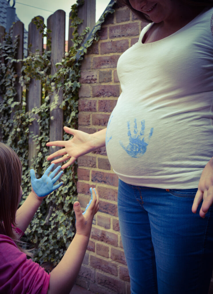 Gender Revealing: Handabdruck auf Babybauch